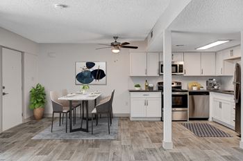 A modern kitchen with a dining table and chairs.